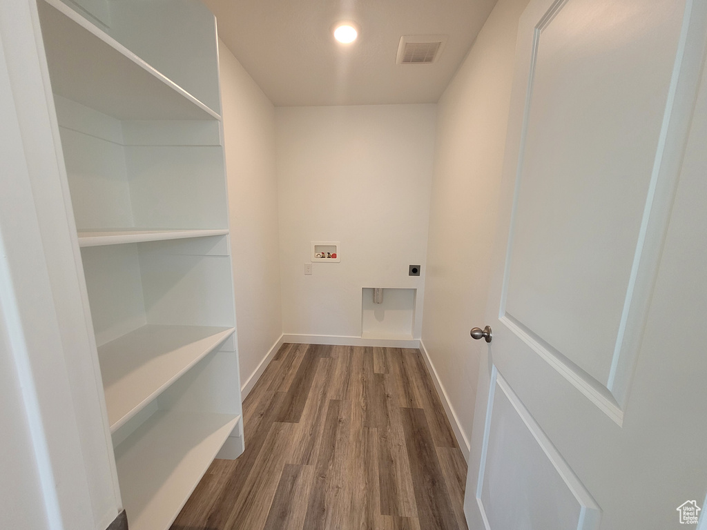 Washroom featuring hookup for an electric dryer, hookup for a washing machine, and dark wood-type flooring