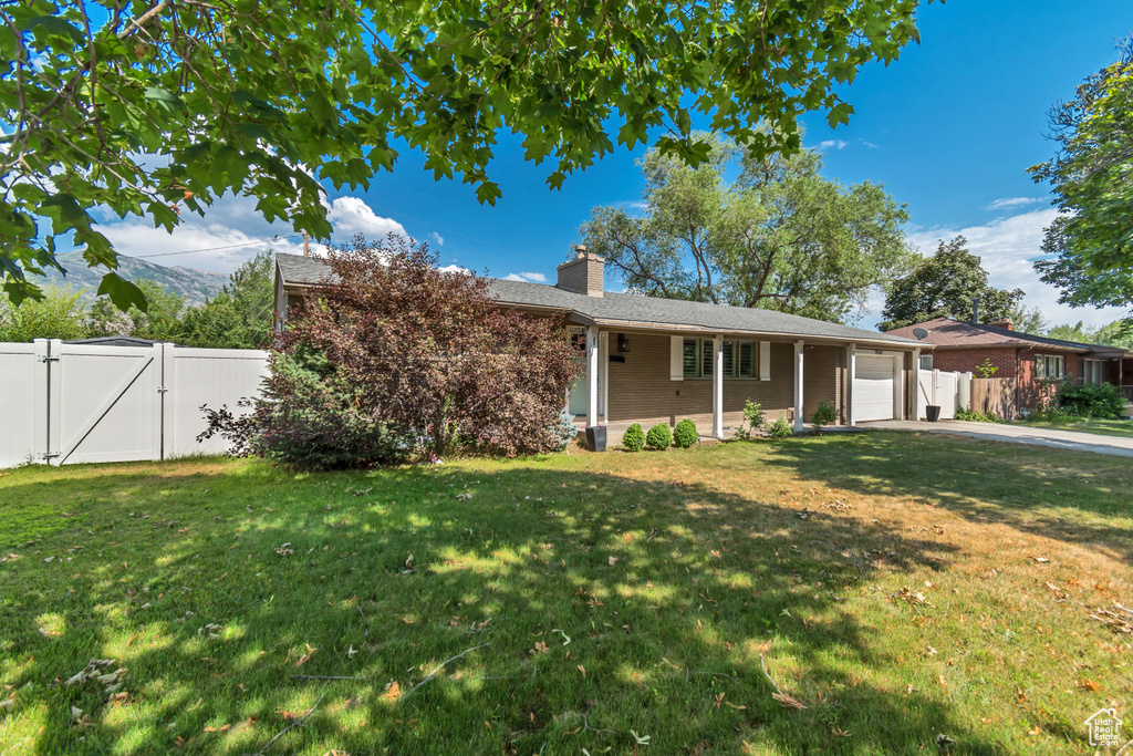 Ranch-style house with a gate, an attached garage, a chimney, and concrete driveway