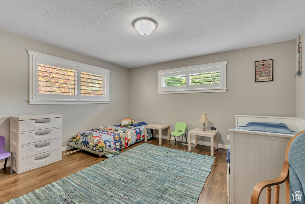 Bedroom with wood finished floors and a textured ceiling