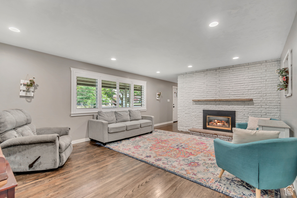 Living room featuring wood finished floors, a fireplace, and recessed lighting