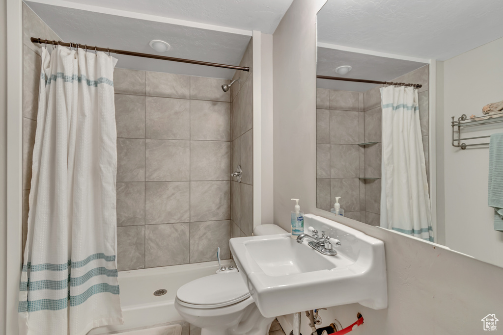Full bath with toilet and tiled shower