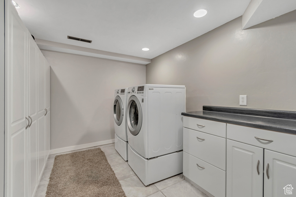 Laundry area with washer and clothes dryer, light tile patterned floors, and recessed lighting
