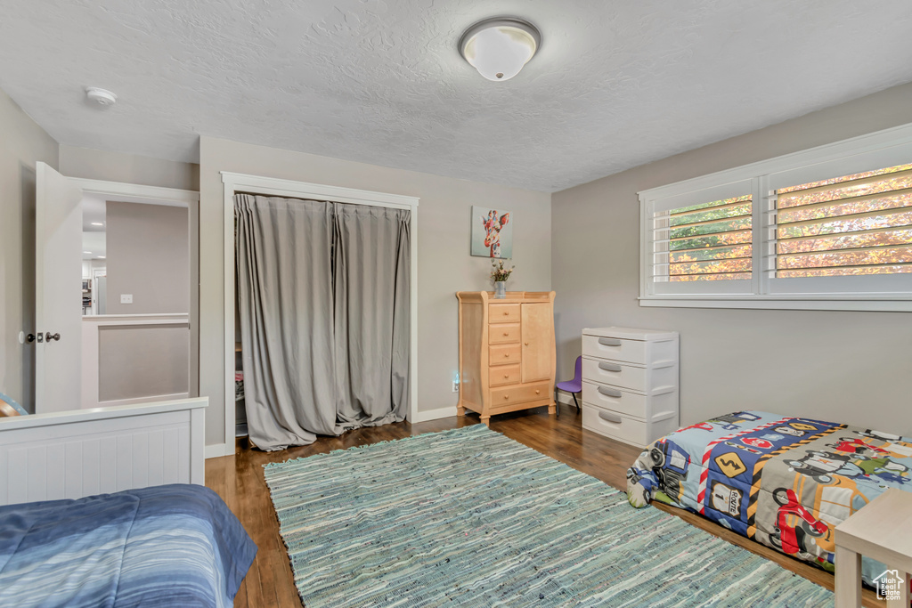 Bedroom with wood finished floors and a textured ceiling