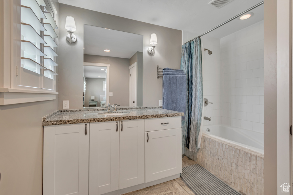 Full bath featuring tiled shower / bath, vanity, and recessed lighting