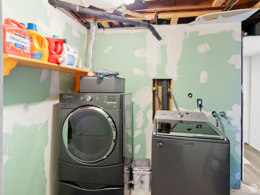 Laundry room featuring washing machine and dryer and wood finished floors