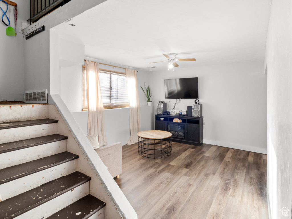 Staircase with ceiling fan and wood finished floors