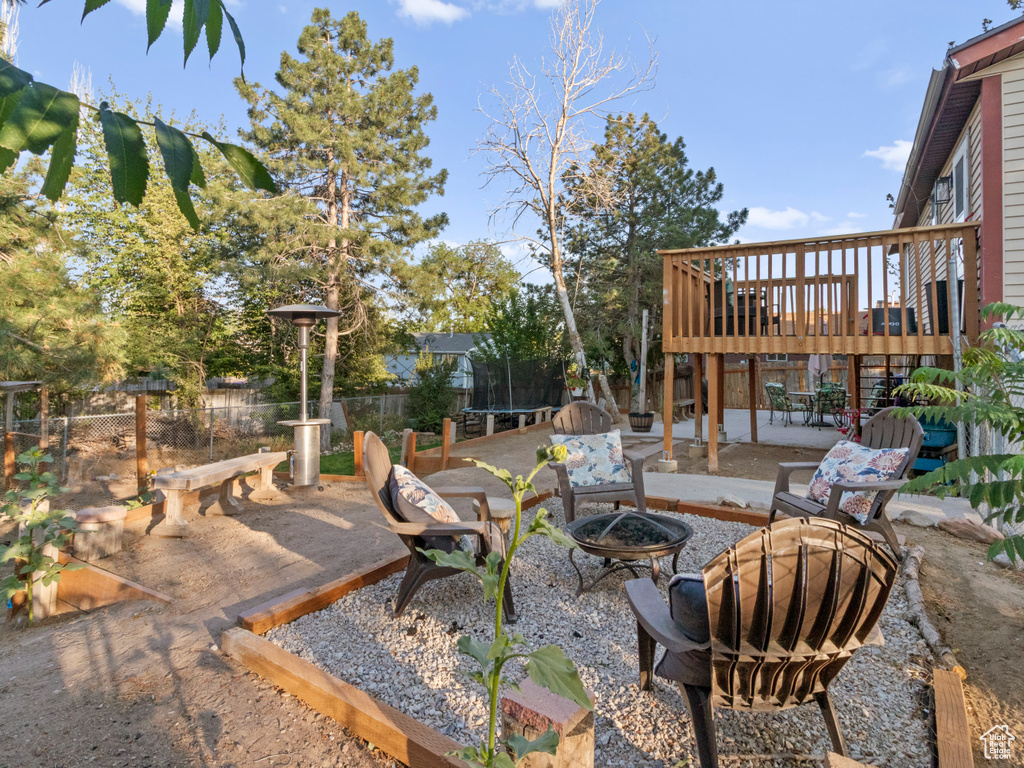 View of patio / terrace with a trampoline, a fire pit, and a wooden deck