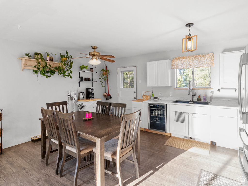 Dining room with beverage cooler, healthy amount of natural light, and wood finished floors