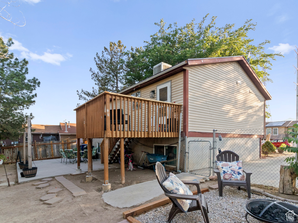 Back of property with a patio, a deck, stairs, a fenced backyard, and a gate