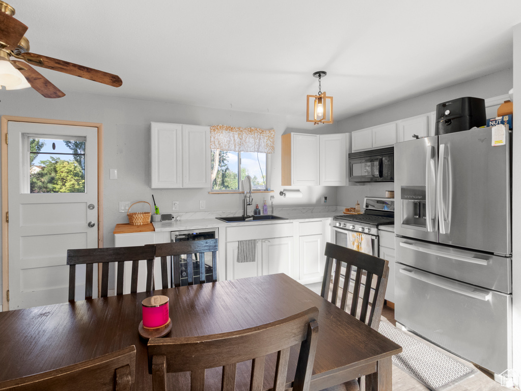 Kitchen with stainless steel appliances, healthy amount of natural light, white cabinets, and light countertops