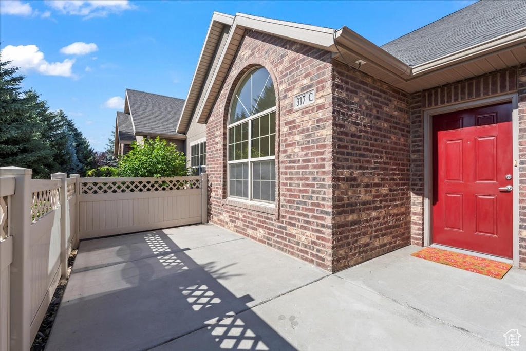 Property entrance featuring brick siding and roof with shingles