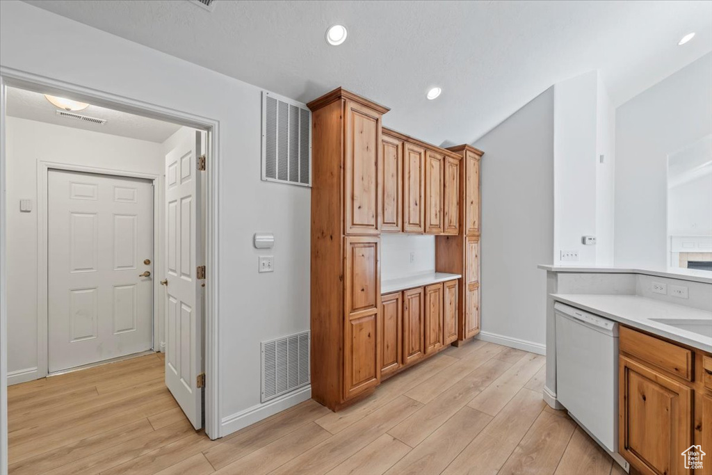 Kitchen with white dishwasher, light wood-style flooring, light countertops, brown cabinets, and recessed lighting