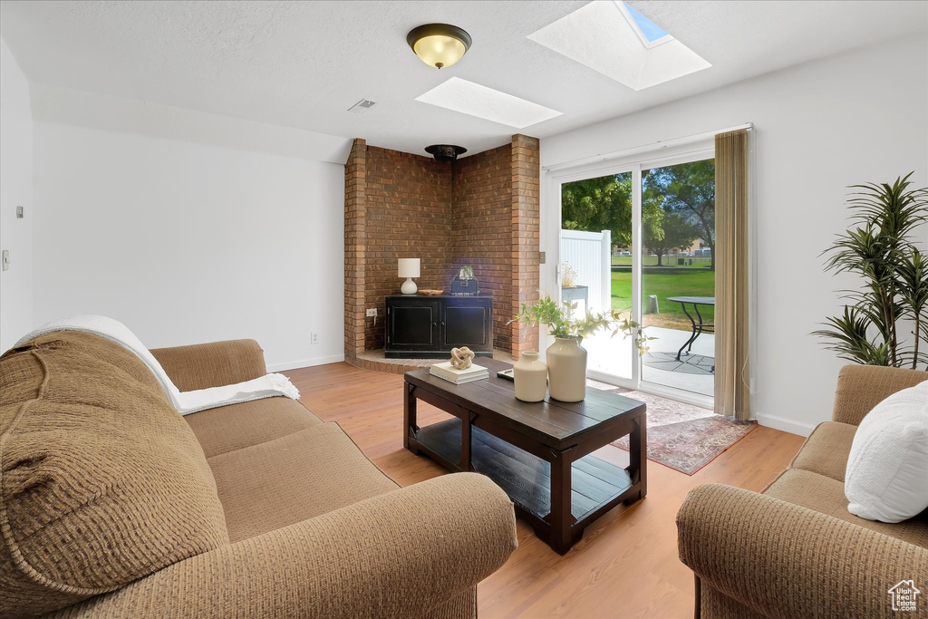 Living area with a skylight and light wood finished floors