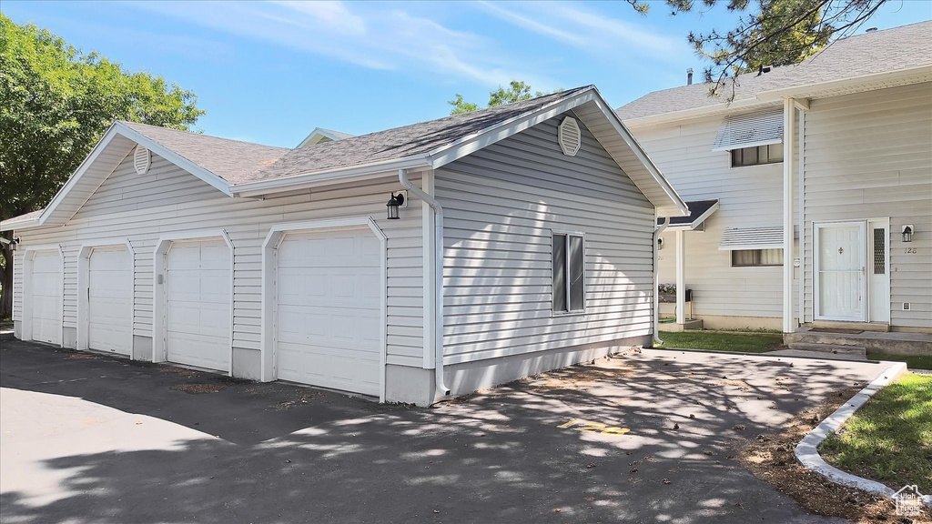 View of side of home with roof with shingles