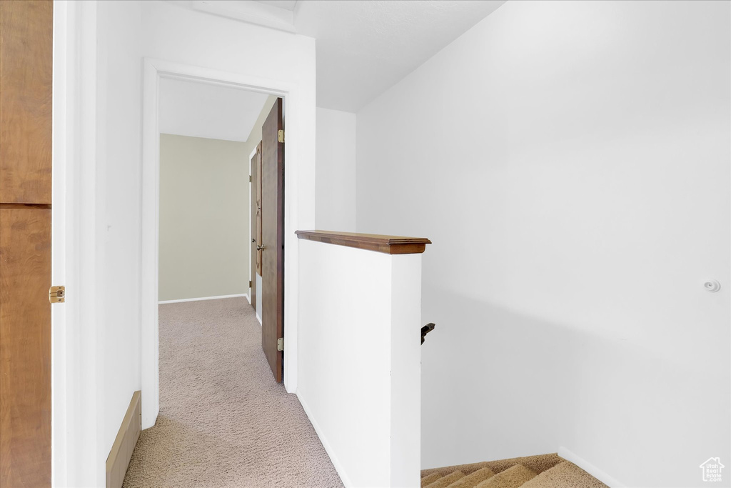 Corridor with carpet flooring and an upstairs landing
