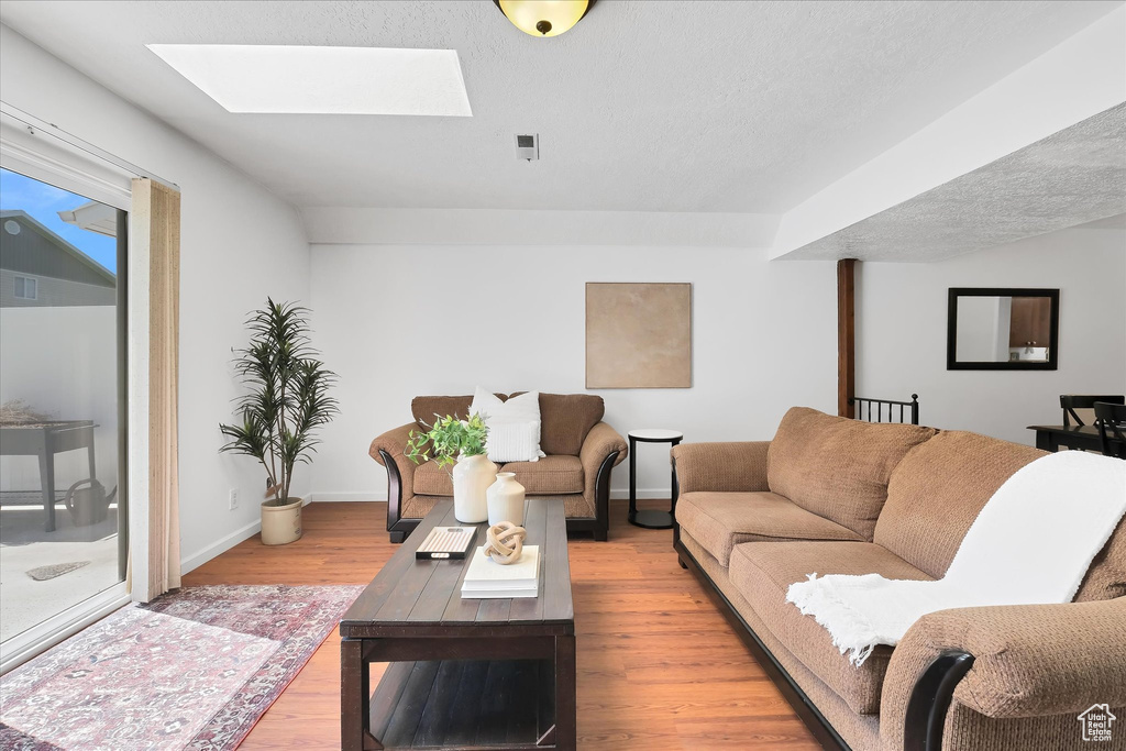 Living room featuring a skylight and light wood-style floors