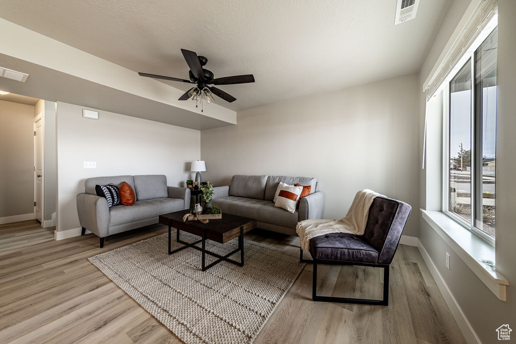 Living room featuring light wood-type flooring and ceiling fan