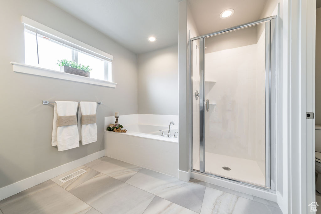 Full bath with a bath, a shower stall, recessed lighting, and marble finish flooring