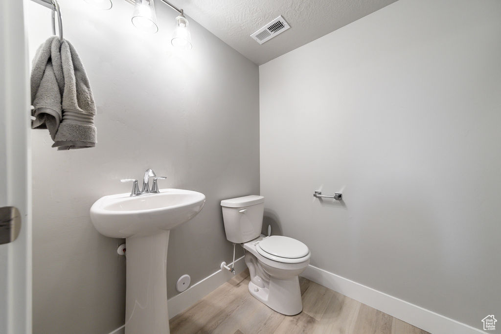Bathroom with wood finished floors and a textured ceiling