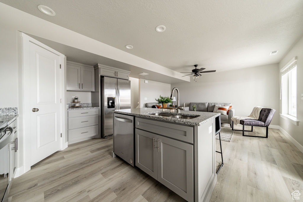 Kitchen featuring gray cabinets, appliances with stainless steel finishes, light wood-style flooring, a ceiling fan, and recessed lighting