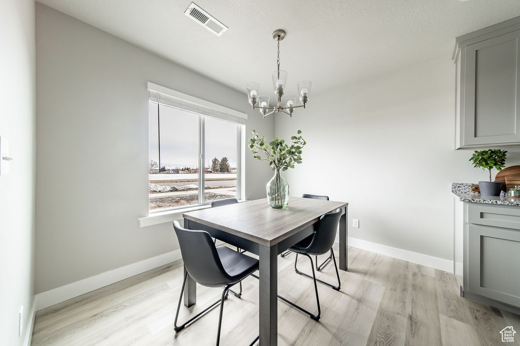 Dining space with a chandelier and light wood-style floors