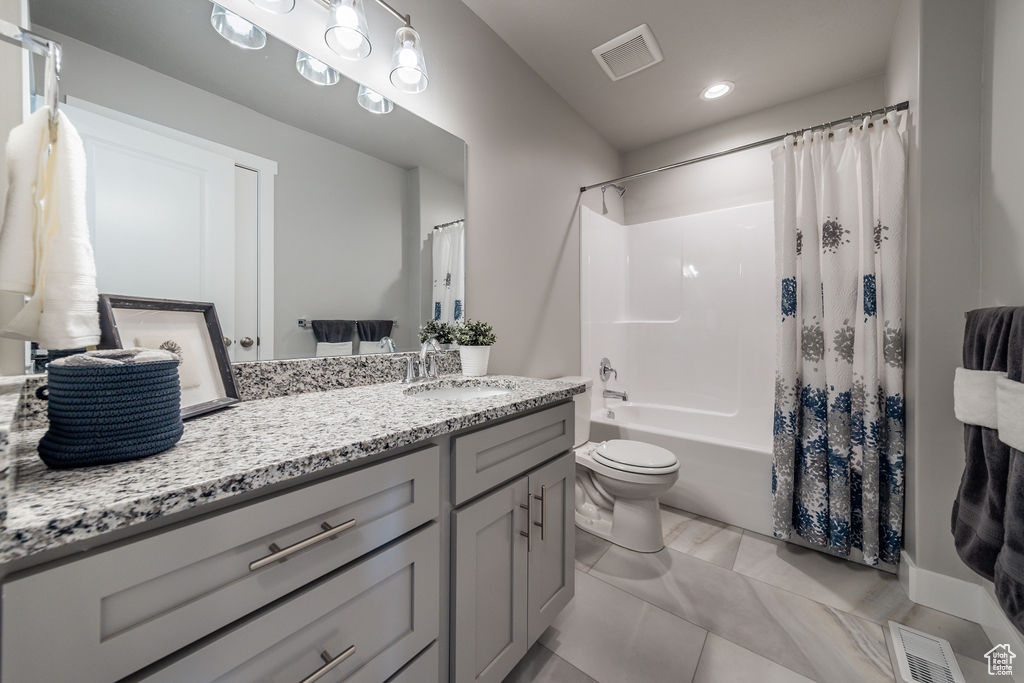 Full bathroom with vanity, shower / tub combo, and recessed lighting