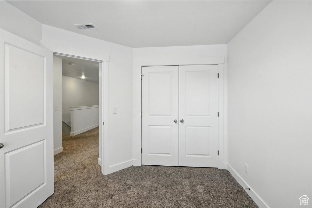 Unfurnished bedroom featuring carpet flooring and a closet