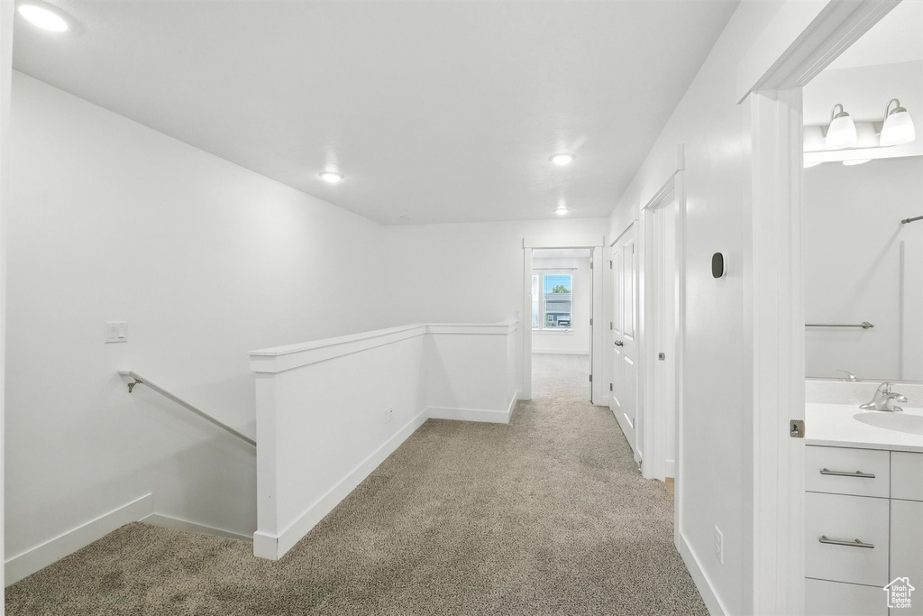 Corridor with an upstairs landing, carpet floors, and recessed lighting