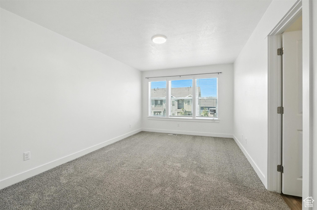 Carpeted spare room with baseboards