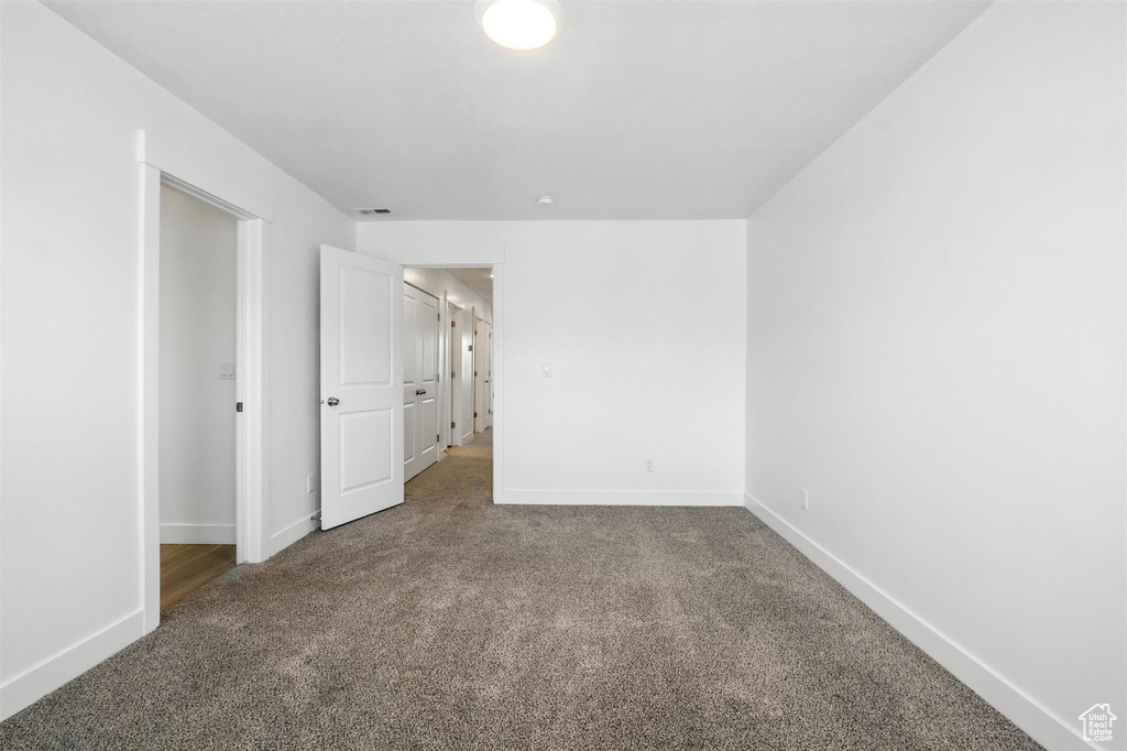 Carpeted spare room featuring baseboards