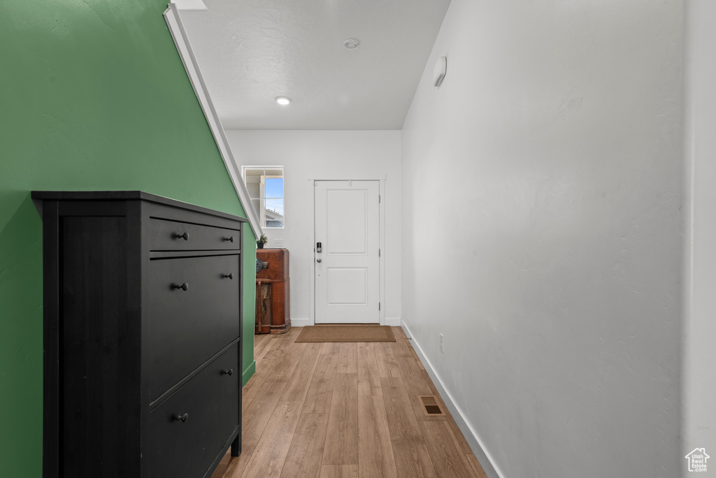 Hall with light wood finished floors and baseboards