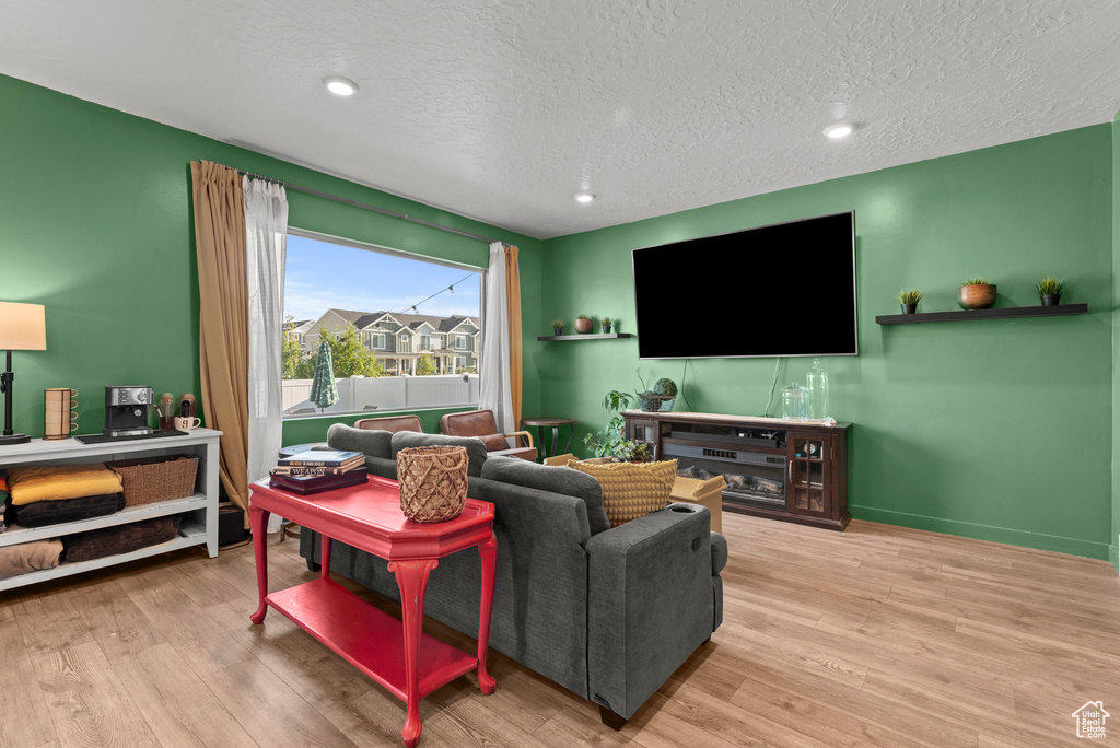 Living area with wood finished floors, a textured ceiling, and recessed lighting