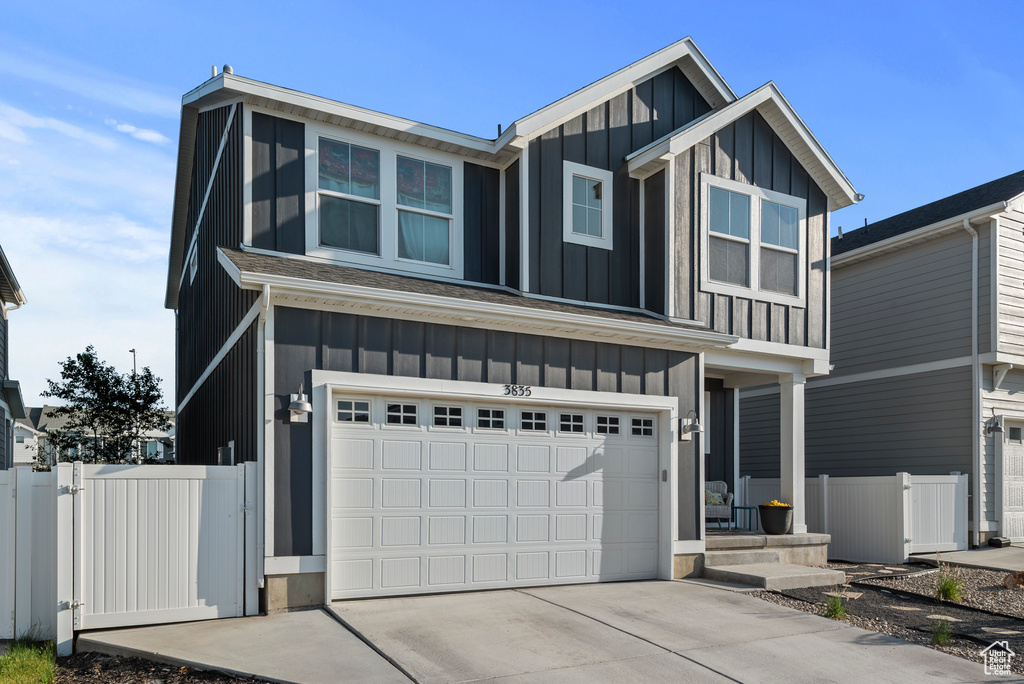 View of front of house featuring board and batten siding, a garage, and concrete driveway