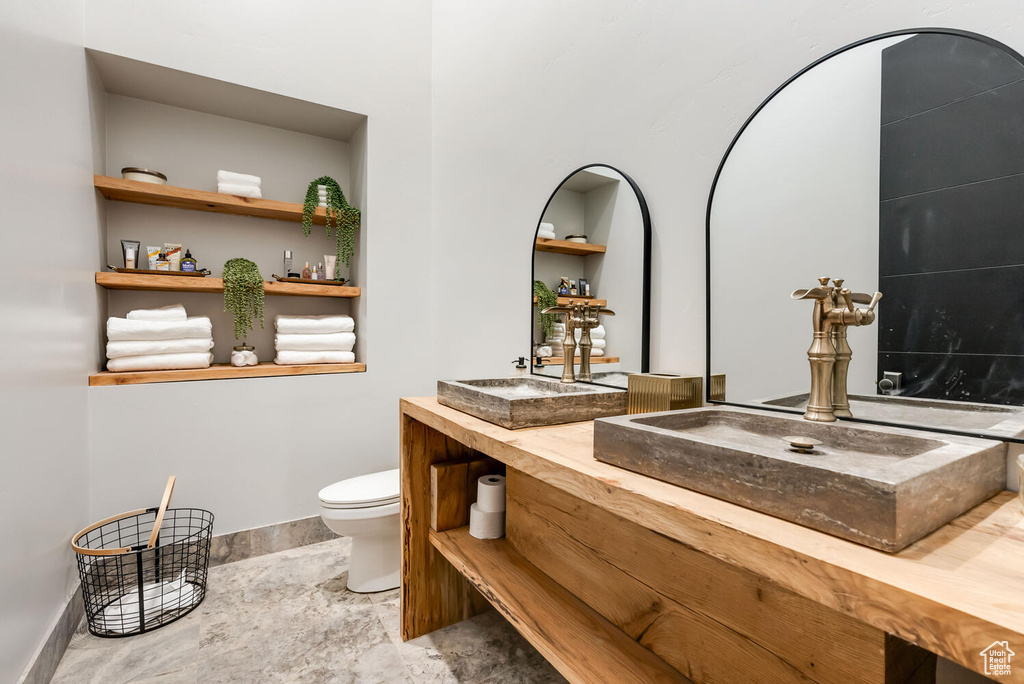 Full bathroom with double vanity and stone finish flooring