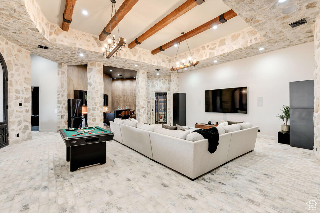 Living area with beamed ceiling, pool table, wood finished floors, and a high ceiling
