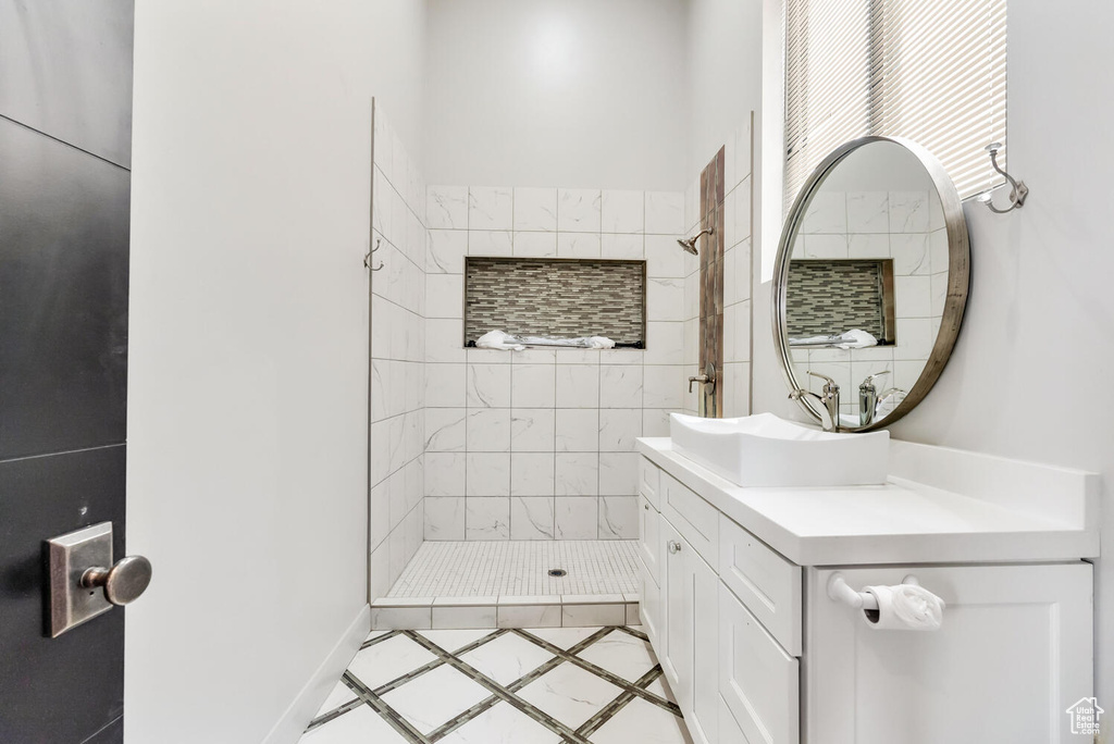 Full bath with a shower stall, vanity, and inlaid floor details