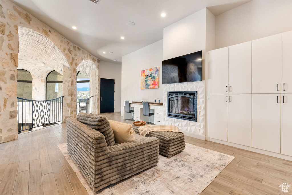 Living area featuring a fireplace, light wood finished floors, and recessed lighting