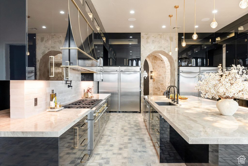 Kitchen with high end appliances, tasteful backsplash, modern cabinets, dark cabinets, and recessed lighting