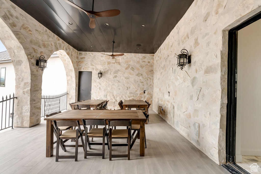Dining area with arched walkways, ceiling fan, light wood-style flooring, and wood ceiling