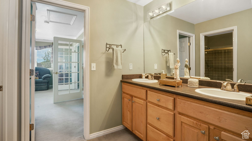 Full bath featuring double vanity and tiled shower
