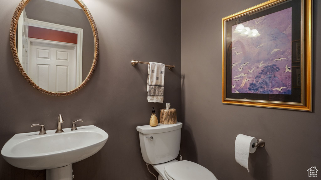 Half bathroom featuring a sink and toilet