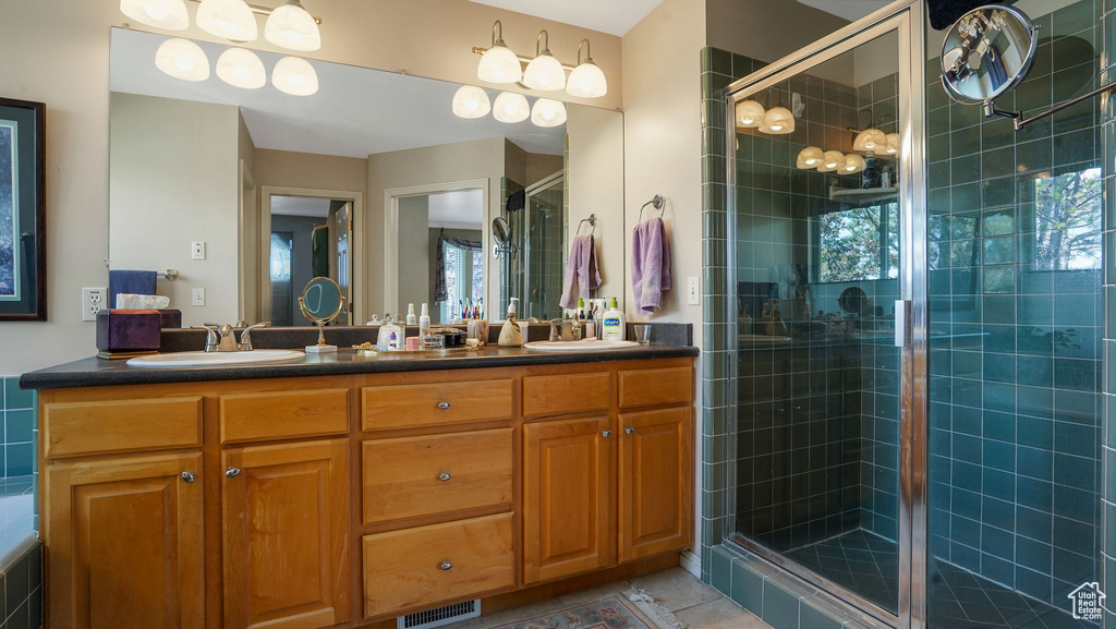 Bathroom with a stall shower, double vanity, and tile patterned flooring