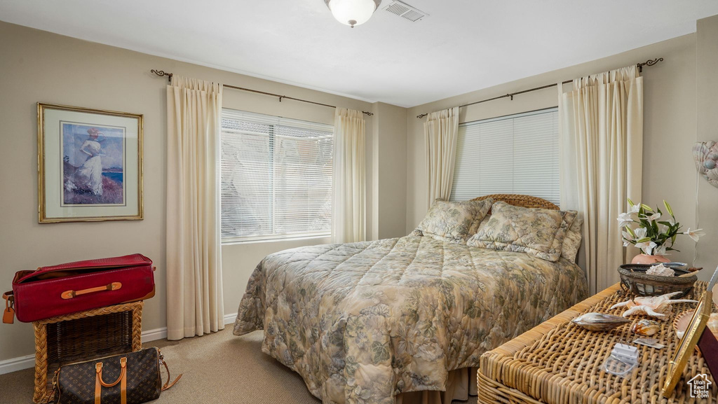 Bedroom featuring carpet and baseboards