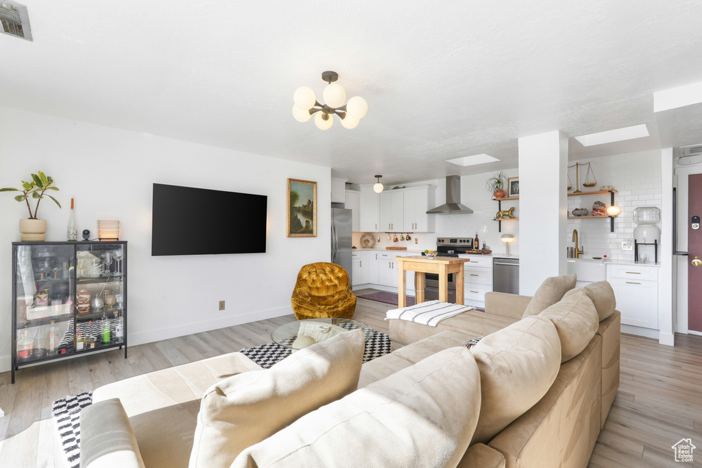 Living room with light wood-style floors and a chandelier