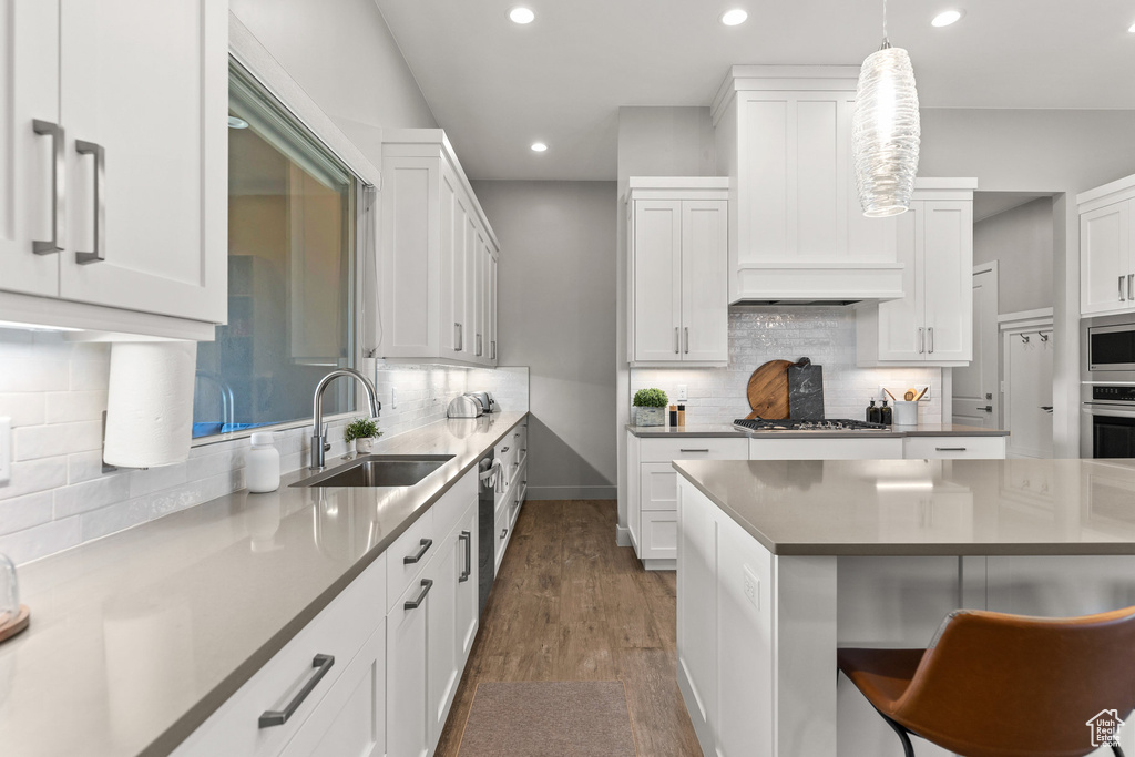 Kitchen with recessed lighting, backsplash, and white cabinetry