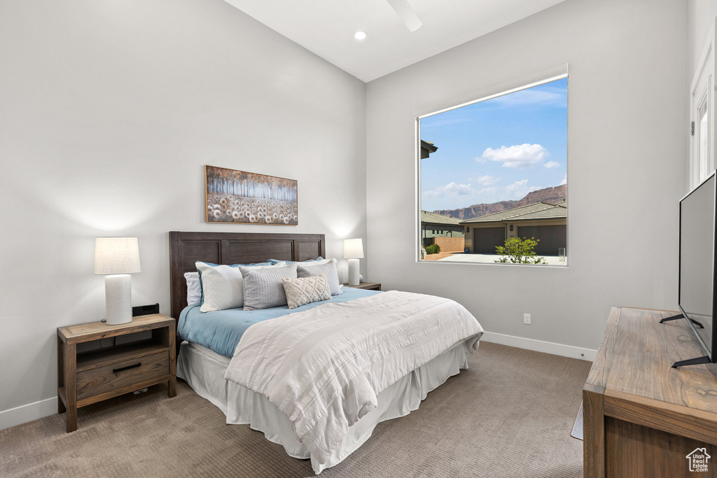 Carpeted bedroom with vaulted ceiling and a ceiling fan