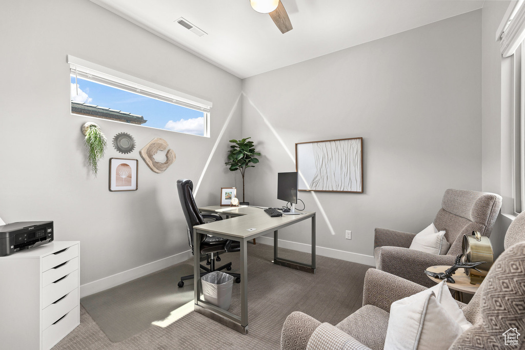 Carpeted office space featuring baseboards and ceiling fan