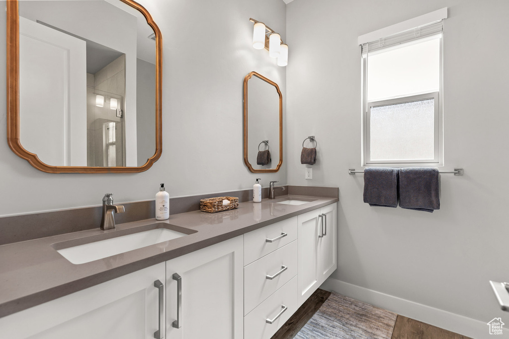 Full bath featuring double vanity and wood finished floors