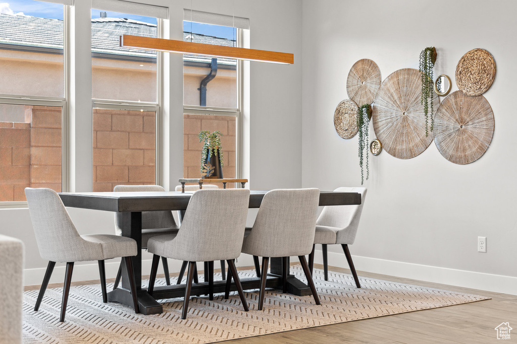 Dining room with wood finished floors and healthy amount of natural light