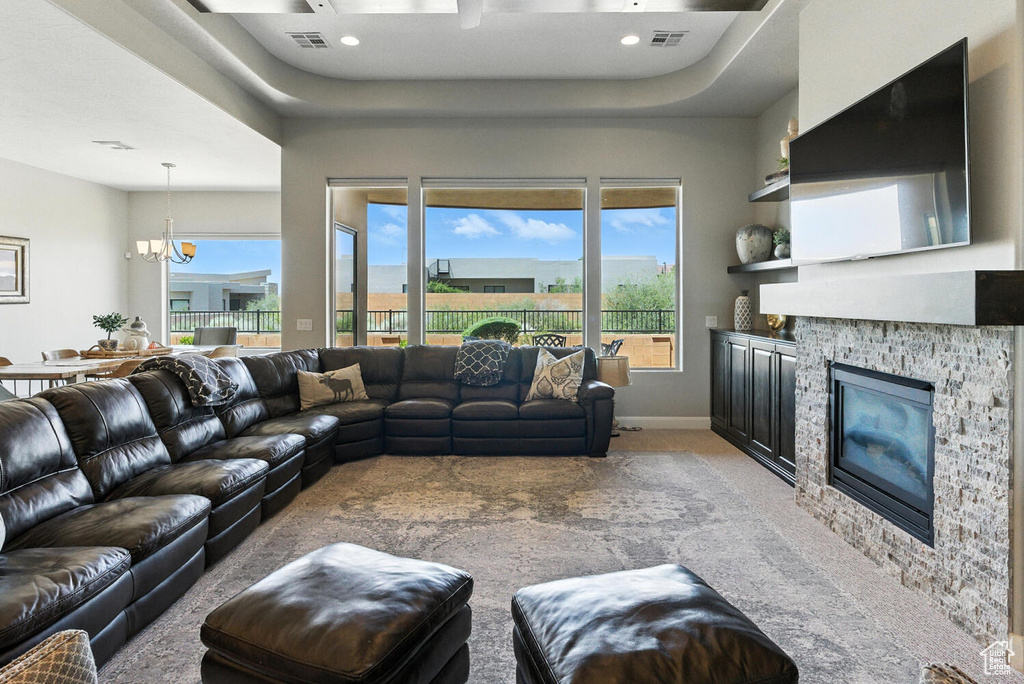 Carpeted living room featuring a chandelier, a glass covered fireplace, and recessed lighting